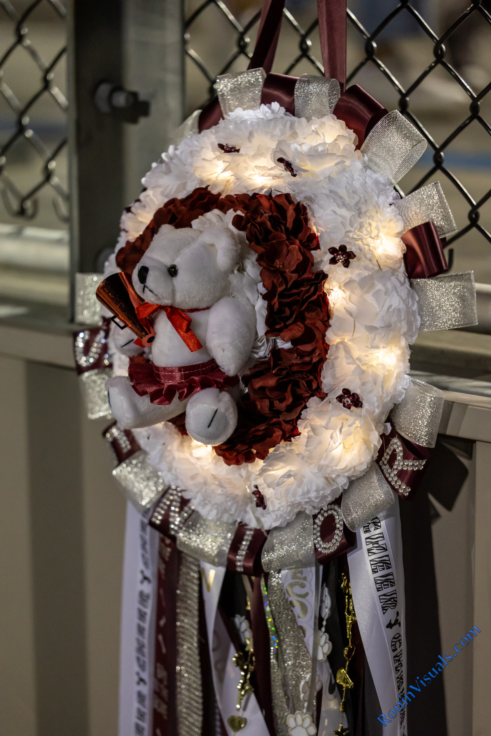 A Waller Bulldog cheerleader's homecoming mum hangs on the football stands while she cheers on the team during the 2022 season. The tradition of making unique and visuallying interesting mums and garters for Texas high school homecoming games and dances has gotten bigger every year. (photo courtesy RoninVisuals.com)