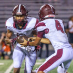 Freshman quarterback T.K. Gaines (4) hands the ball off to Robert Carter (11) during the trick play that netted the Bulldogs their second touchdown of the night. The Waller Bulldog football team slips against Conroe Grand Oaks, 17-14, for the Bulldog’s first loss of the 2024 campaign, at Moorehead Stadium in Conroe, Sept. 5, 2024. (Photo by Creighton Holub, courtesy RoninVisuals.com)